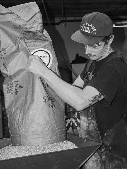 Connor Blanchard milling grains during mash-in at Luppolo Brewing