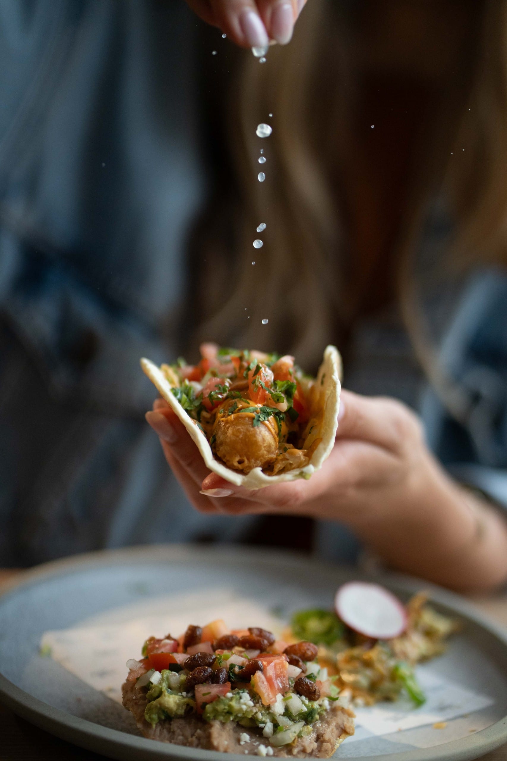 sprinkling lime juice on a fish taco at Four Winds Brewing in Delta BC