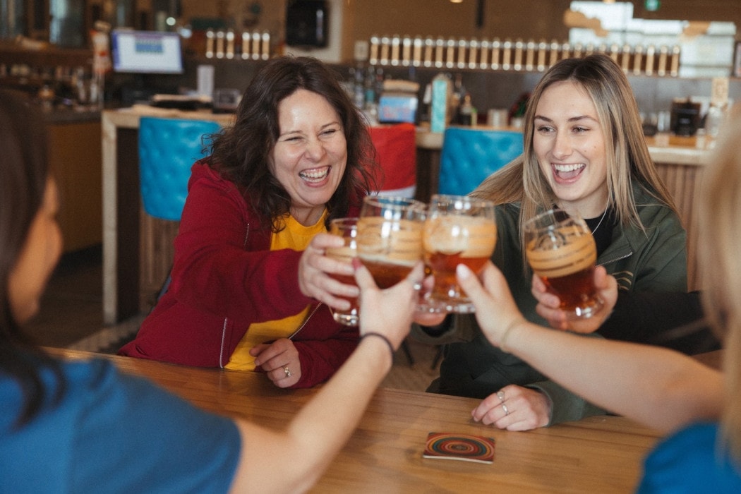 a group of ladies cheers their pints of craft beer at Encore Brewing in Cranbrook, BC