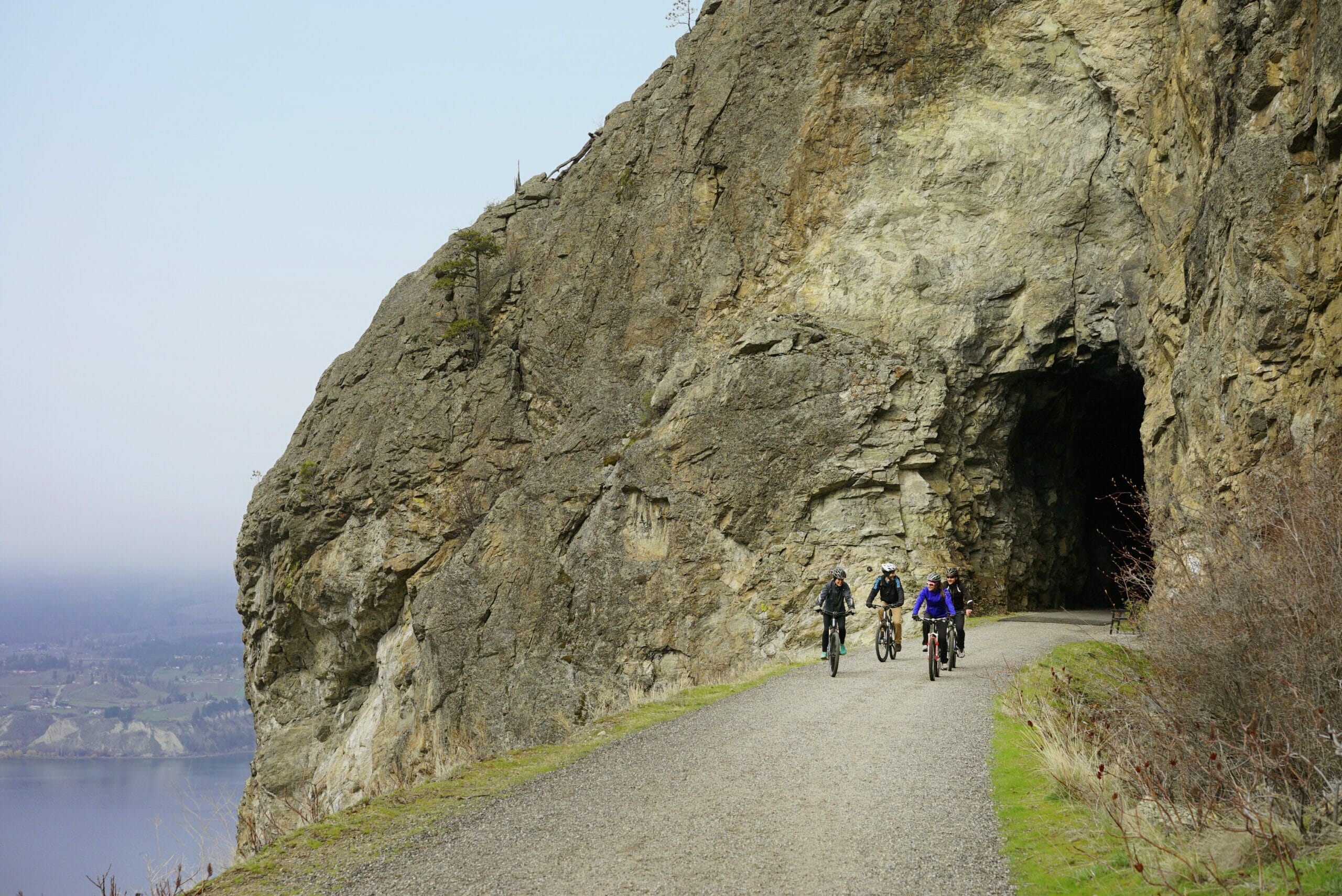 Cyclists emerging from LIttle Tunnel on the Kettle Valley Railway in Penticton, BC