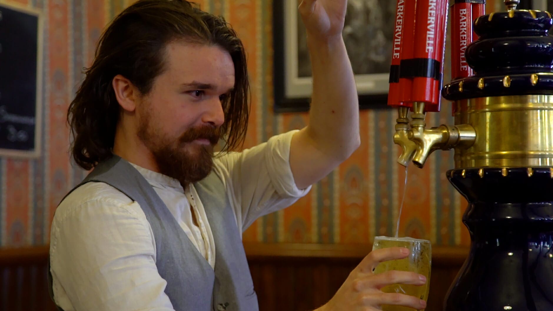 man in historic costume pours a pint of beer in gold rush town of Barkerville