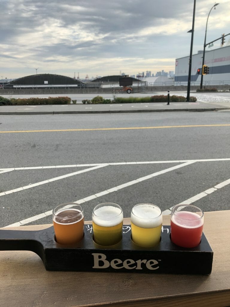a flight of beer from Beere Brewing with a view of Vancouver's North Shore