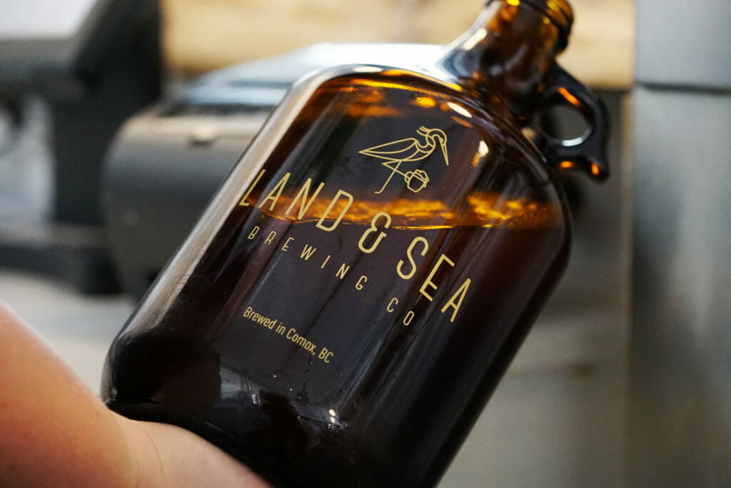 Land & Sea branded growler being filled with beer