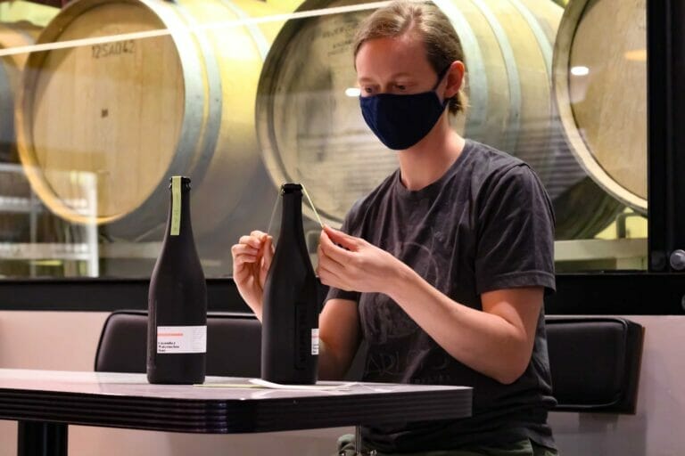 Roxanne putting labels on the bottles at The Bakery Brewing in Port Moody on the BC Ale Trail