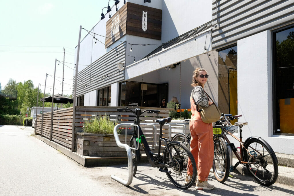 A cyclist next to the bike rack at Steel & Oak Brewing in New Westminster, BC