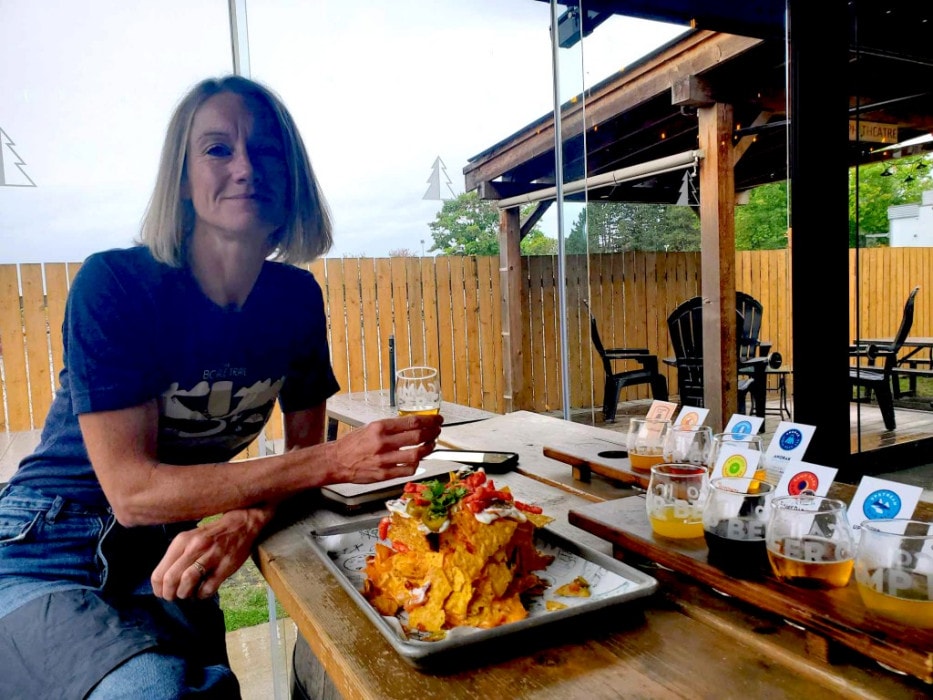 author Hannah Irvine enjoying a flight and nachos at Camp Beer Co in Langley, BC
