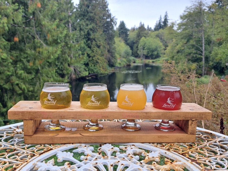 A flight of beer with an idyllic pond in the background at Locality Brewing in Langley, BC