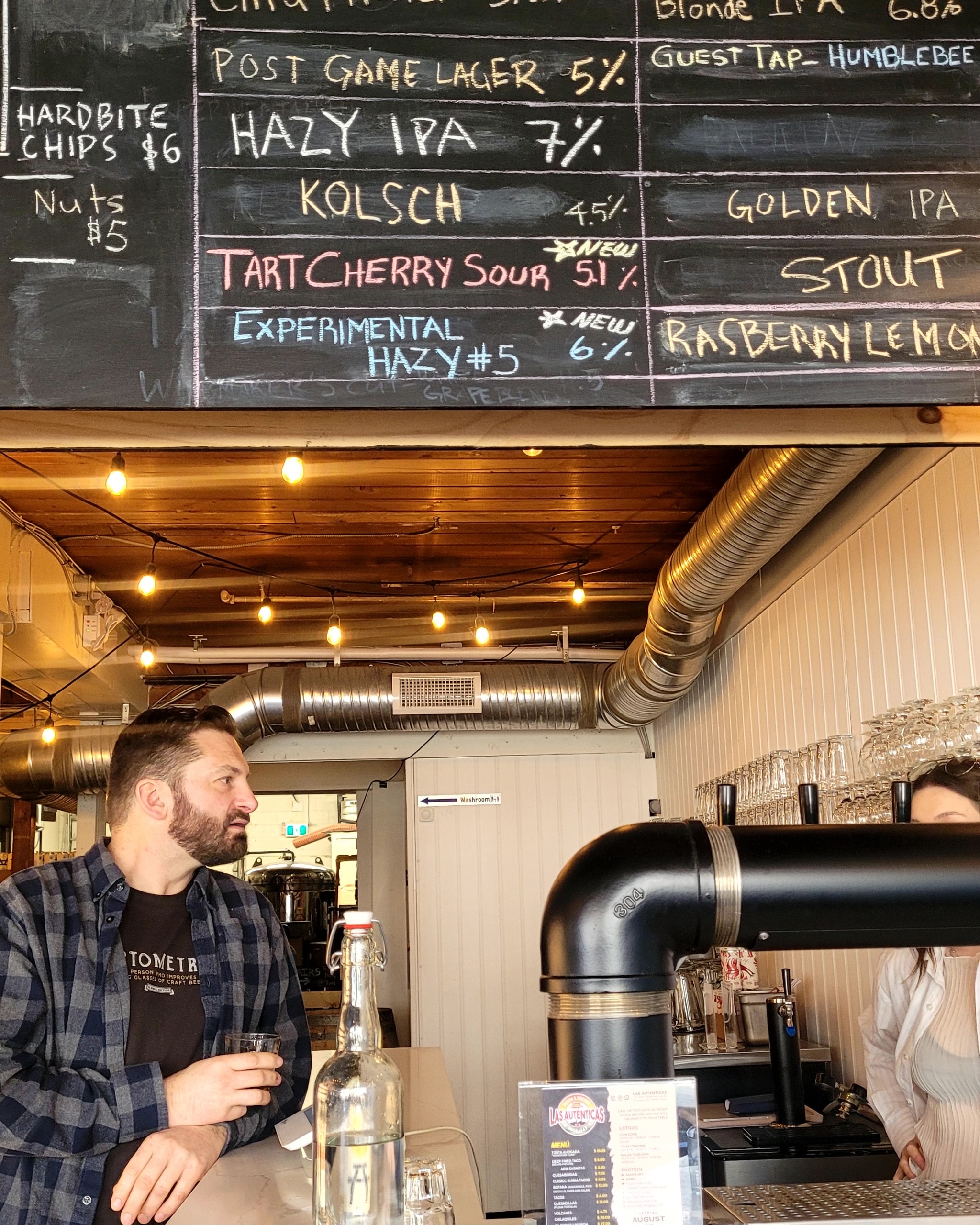 The bar and overhead tap list at Brewing August in Vancouver (photo: Noëlle Phillips)