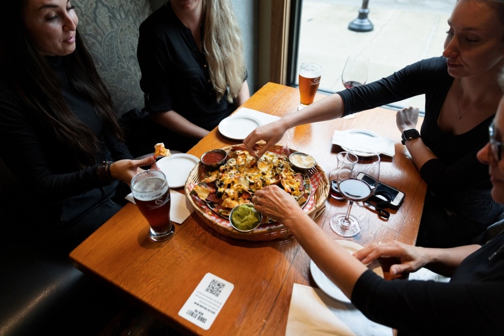 four ladies share a large plate of nachos along with craft beer and wine at Craig Street Brewing in Duncan, BC