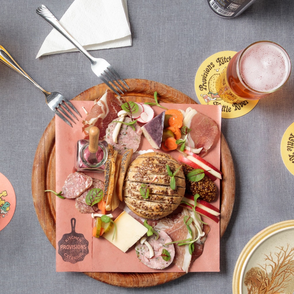 a woman digging in to a salad and wrap meal at Rusted Rake Brewing in Nanoose Bay, BC