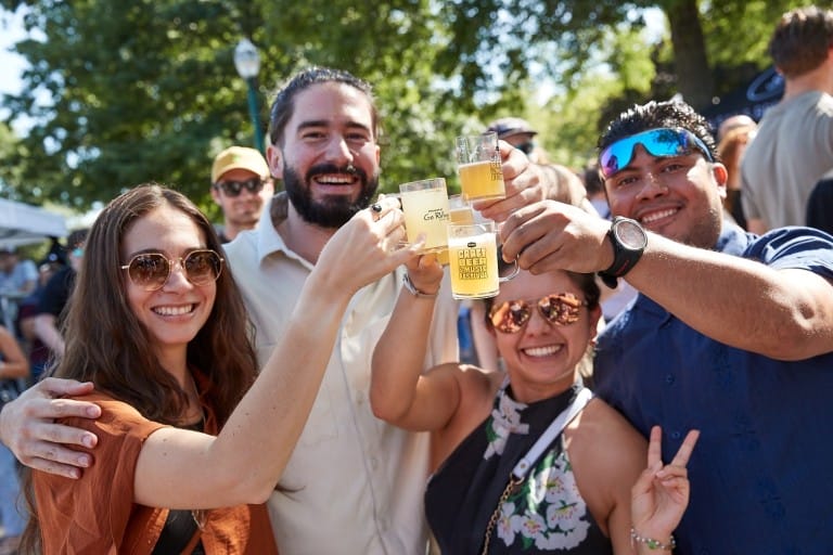a group of people holding up their tasting glasses of craft beer at Vancouver Craft Beer and Music Festival