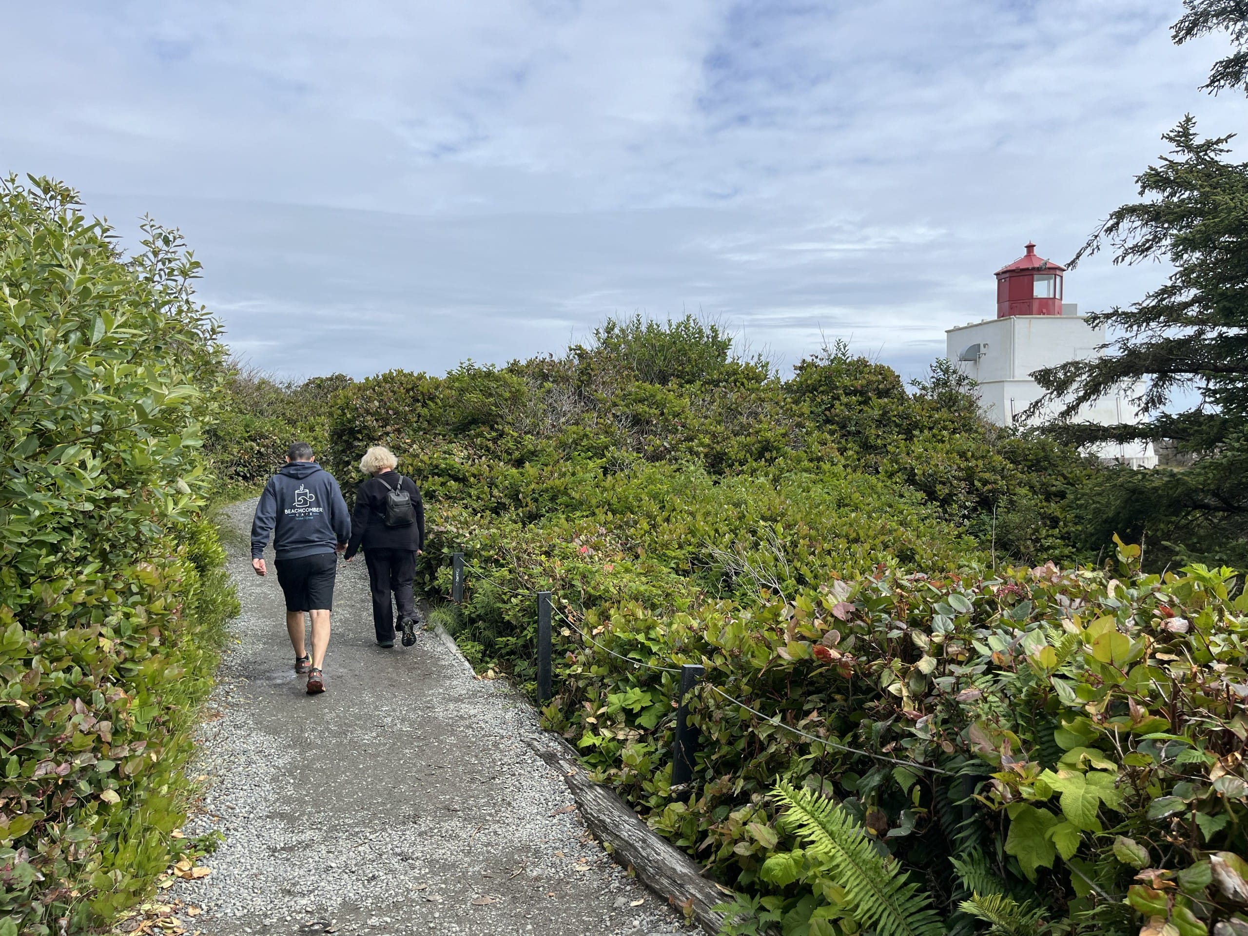 two people walk a smooth gravel path that makes up part of the Lighthouse Loop trail in Ucluelet, BC
