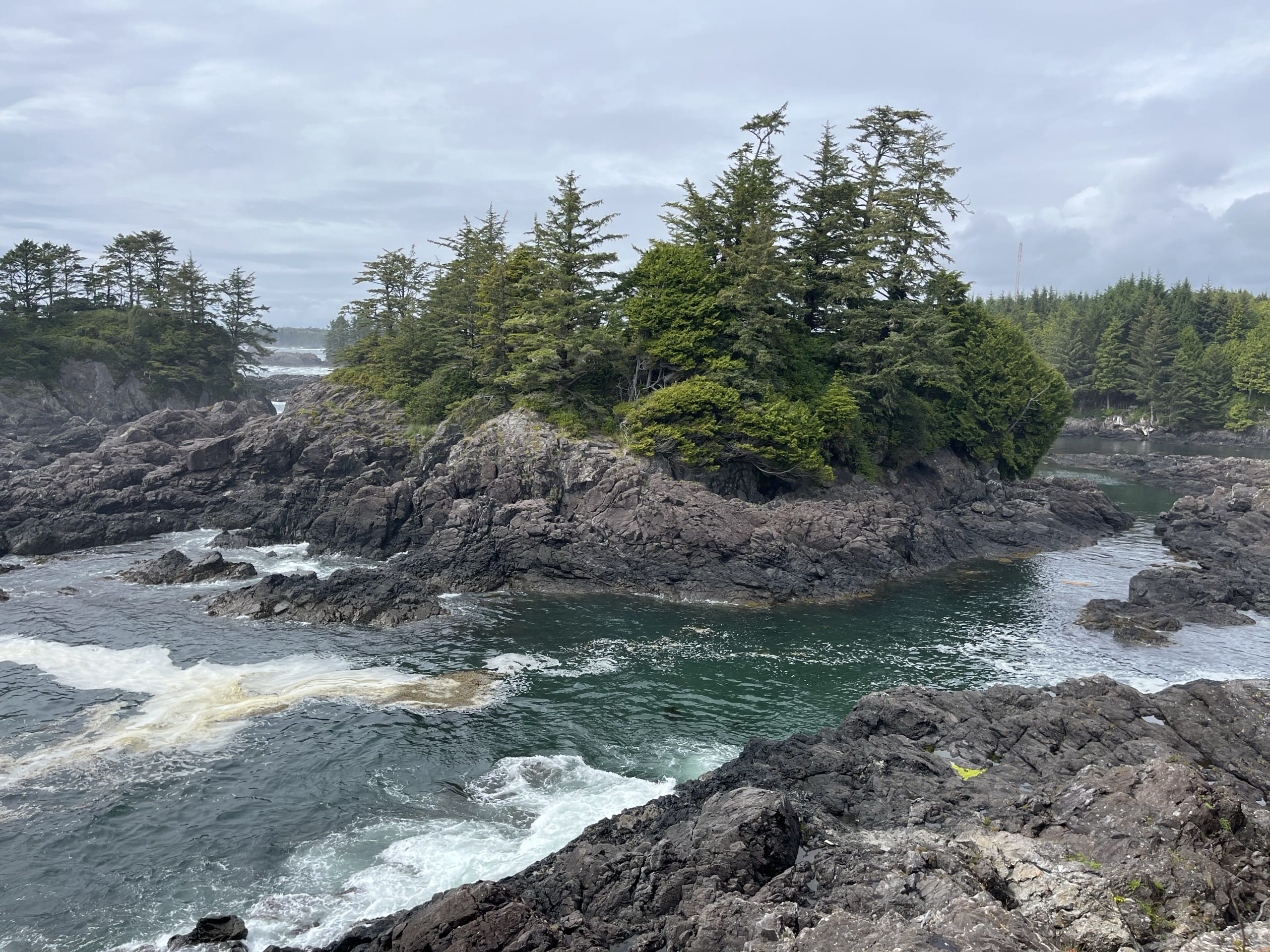 craggy rock islands and incoming waves in a small inlet alongside the Lighthouse Loop trail in Ucluelet on Vancouver Island