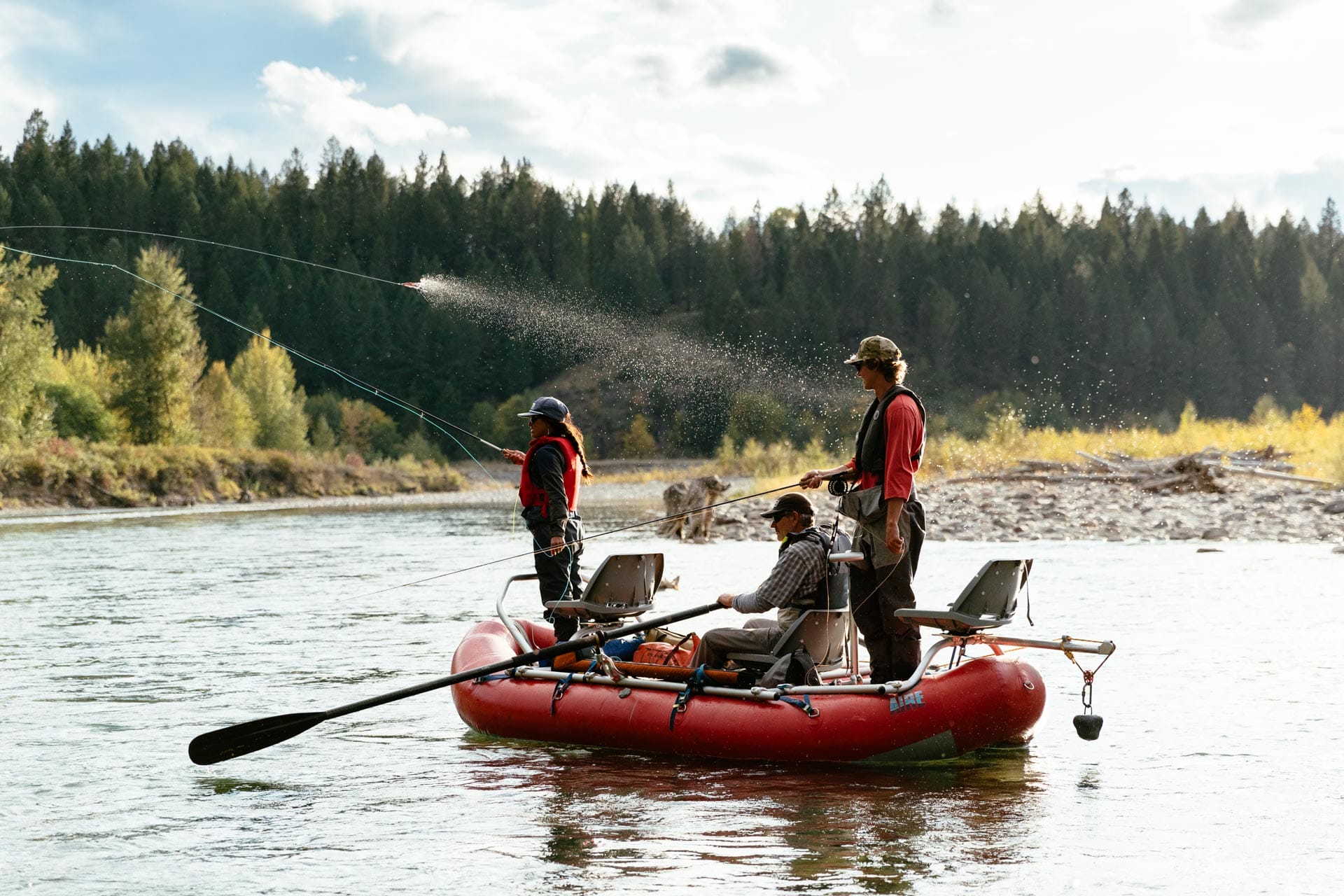 three people in a drift boat fishing one of the local rivers in Fernie, BC