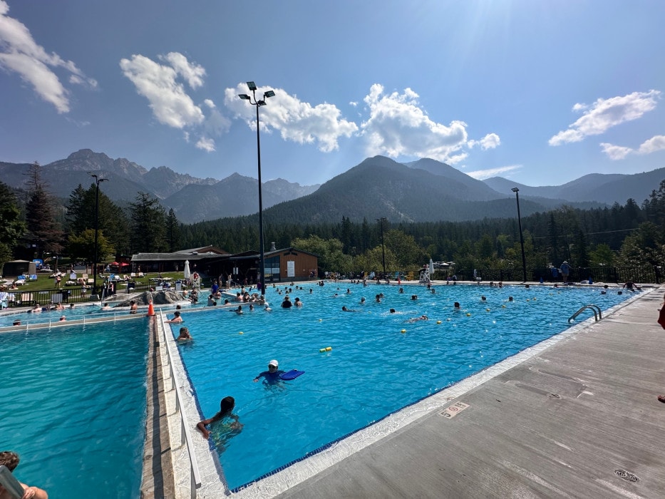 a view of the large hot spring pools at Fairmont Hot Springs with a mountainous and scenic background