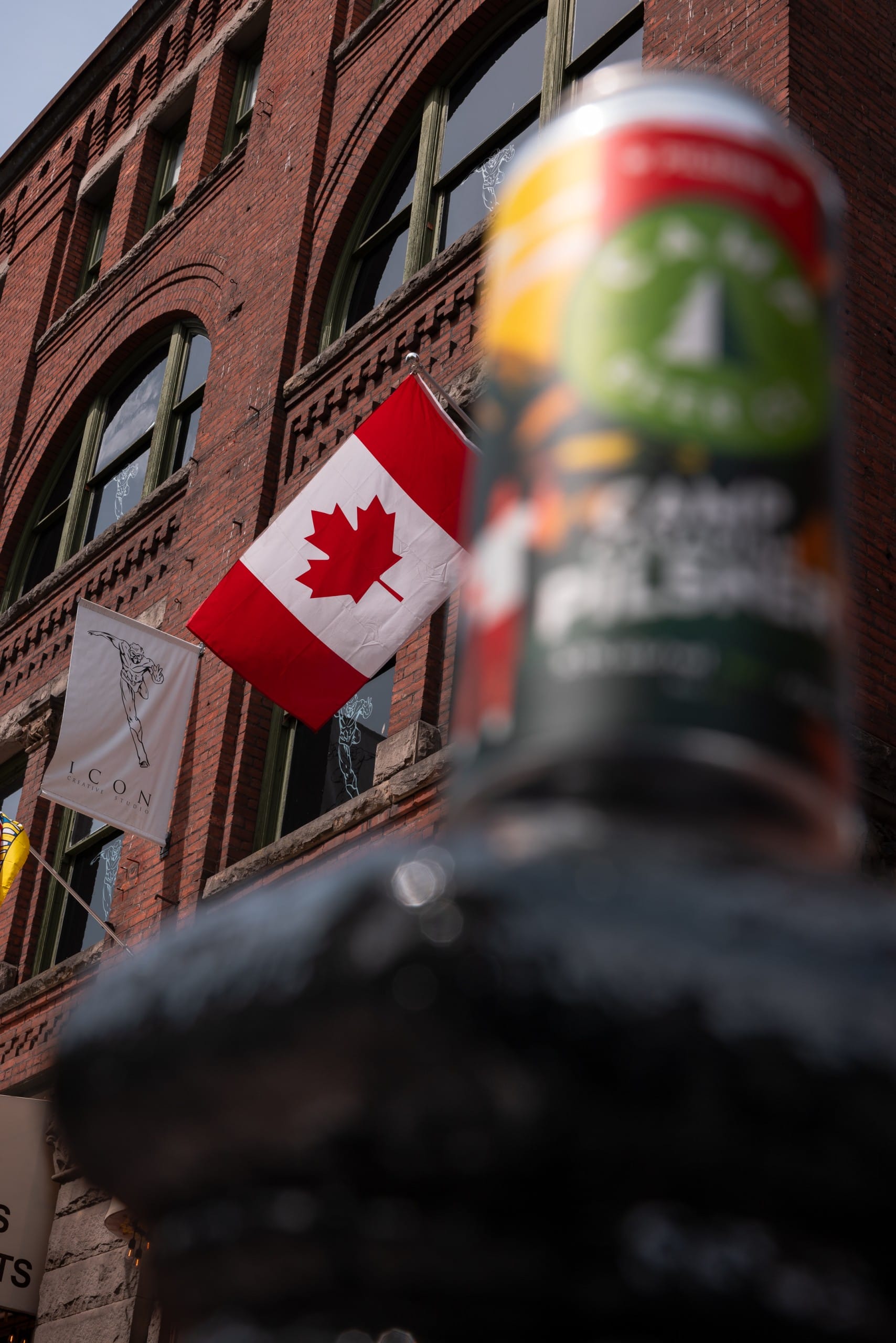 a Canadian flag waves, with a can of Camp Canadian Pilsner in the foreground