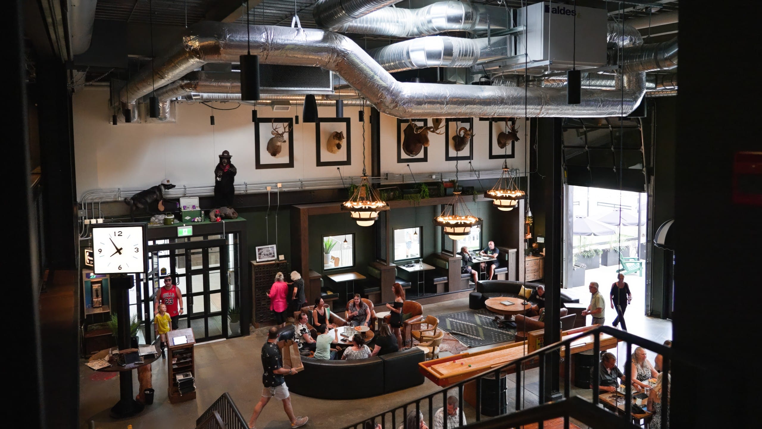 a view of the main taproom at food and craft beer at BNA Brewing in Vernon, BC, from the upstairs lounge and bowlign area
