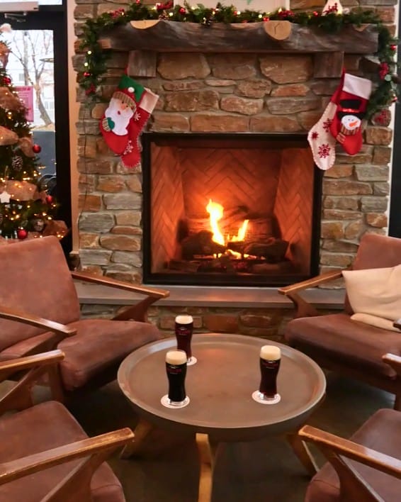 Pints of stout next to the festively decorated fireplace at Lakesider Brewing in West Kelowna, BC