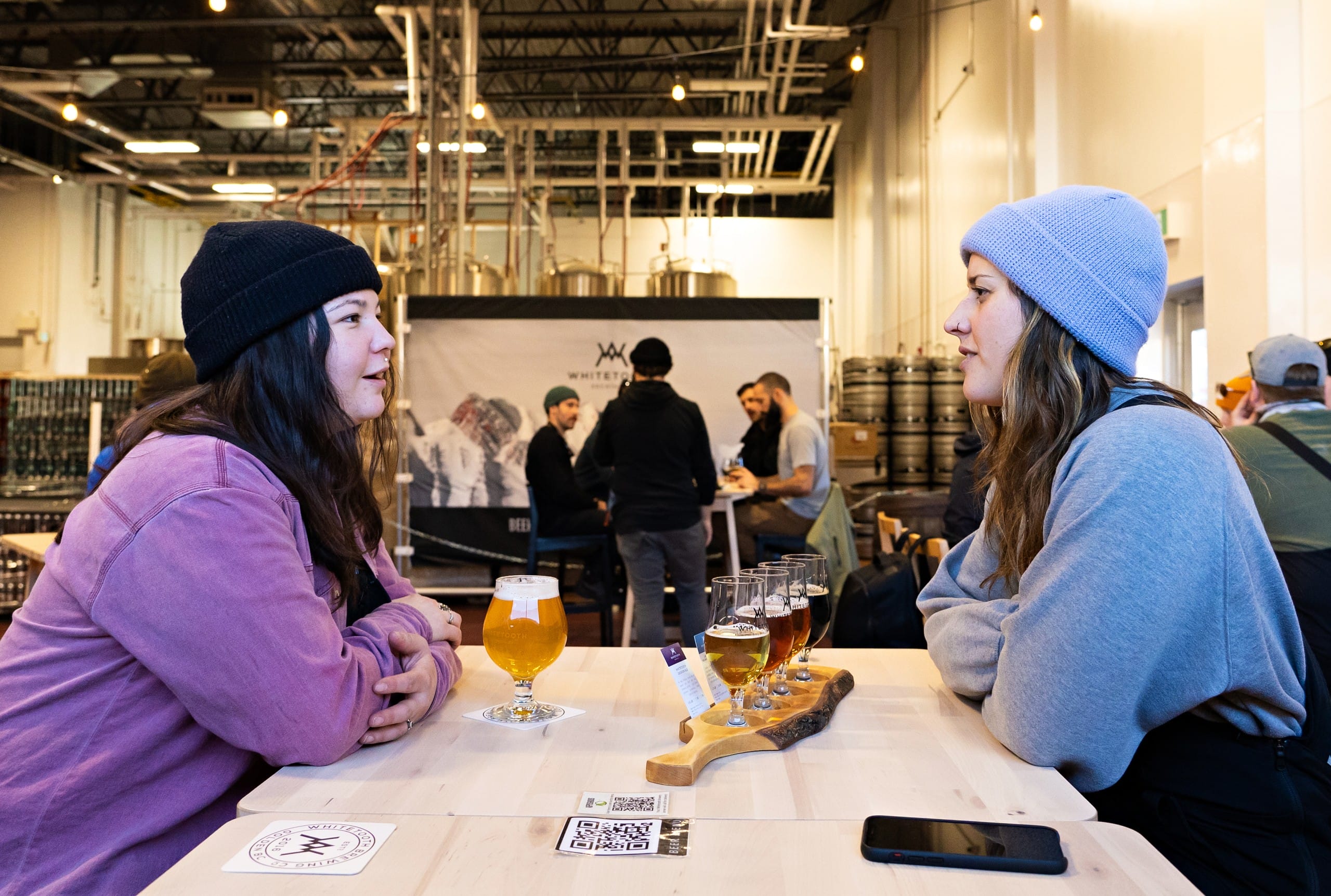two people enjoying craft beers at Whitetooth Brewing in Golden, BC