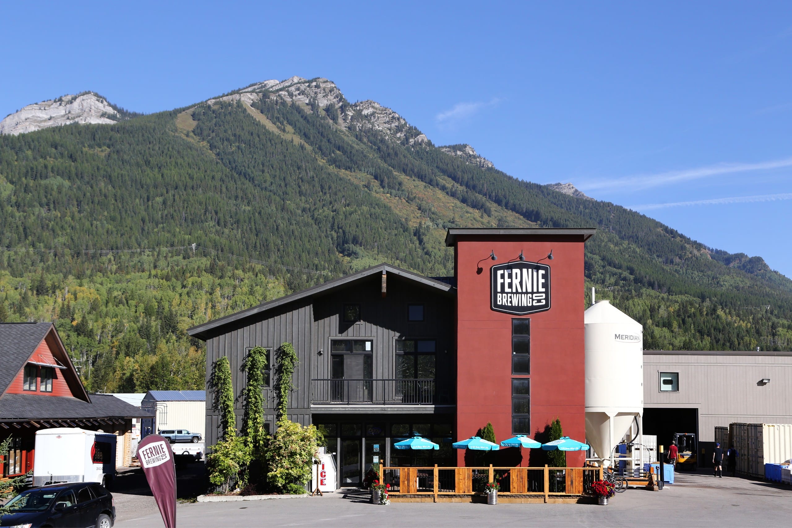 the exterior, with mountains in the background, of Fernie Brewing Co. in Fernie, BC